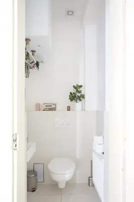 a white bathroom with a toilet and a sink at Mama's apartment in Letna in Prague