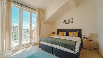 a bedroom with a bed and a large window at Prague Retreat Apartment in Prague