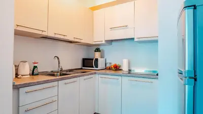 a kitchen with white cabinets and a microwave at Prague Retreat Apartment in Prague