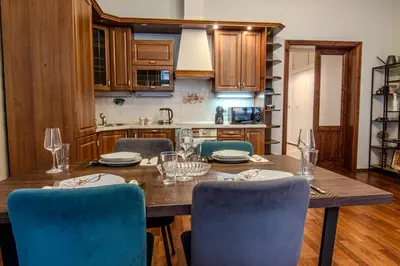 a kitchen with a wooden table and chairs at SMÍCHOV Riverfront Apartment Prague 5, Near Anděl in Prague