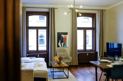 a living room with a bed and a table and a television at SMÍCHOV Riverfront Apartment Prague 5, Near Anděl in Prague
