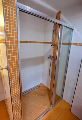 a shower with a glass door in a bathroom at Garden in the city in Prague
