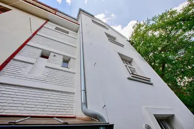 a white building with windows on the side of it at Garden in the city in Prague