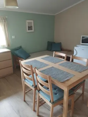 a dining room table and chairs with a kitchen in the background at Apartmány Audy 2 in Mníšek pod Brdy