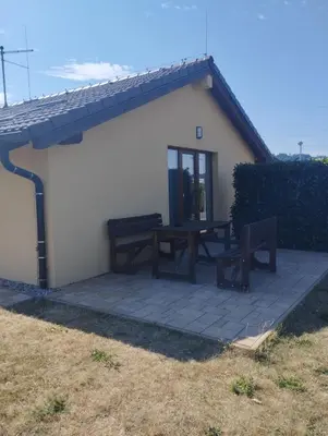 a building with a picnic table and benches on a patio at Apartmány Audy 2 in Mníšek pod Brdy