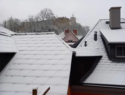 a group of roofs with snow on the roofs at Pod hradbami Křivoklát in Křivoklát