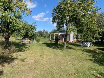a house in a field with a yard with trees at Tiny house - Chatka v Řeži u Prahy in Husinec