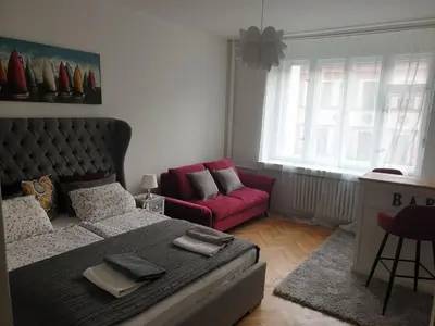 a bedroom with a large bed and a red couch at Newly refurbished central in Prague