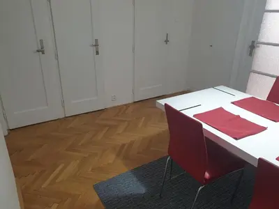a room with a white table and red chairs at Newly refurbished central in Prague