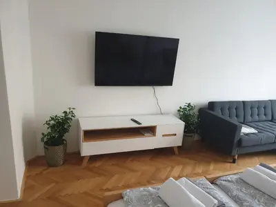 a living room with a couch and a tv on a wall at Newly refurbished central in Prague