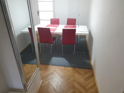 a dining room table with red chairs in a room at Newly refurbished central in Prague