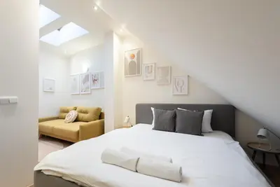 a bedroom with a white bed and a yellow couch at B.O.B. Klimentská in Prague
