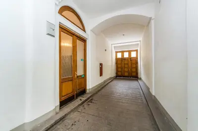 an empty corridor with wooden doors in an empty building at B.O.B. Klimentská in Prague