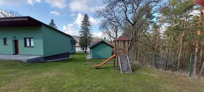 a playground with a slide in front of a house at Apartmán Slapy, slapská přehrada - Nová Živohošť in Křečovice