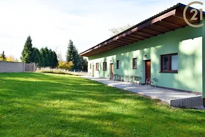 a green building with a grass field next to it at Apartmán Slapy, slapská přehrada - Nová Živohošť in Křečovice