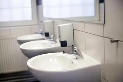 two sinks in a bathroom with two mirrors at Hostel Seven in Prague