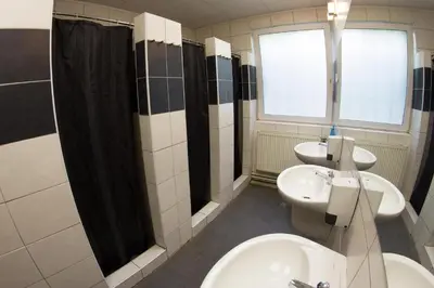 a bathroom with two sinks and a toilet and a window at Hostel Seven in Prague