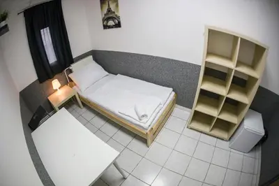 a small room with a bed and a book shelf at Hostel Seven in Prague