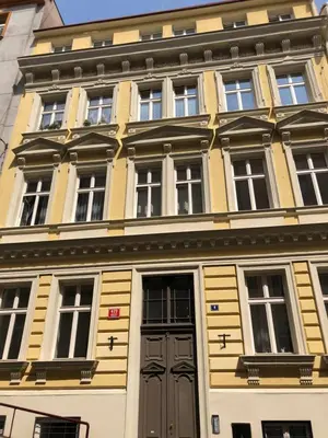 a yellow and white building with a door at Andrews Cosy Apartment in Prague