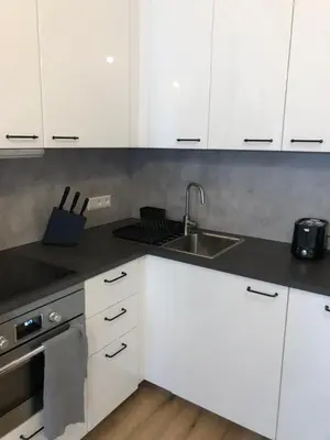 a kitchen with white cabinets and a sink at Andrews Cosy Apartment in Prague