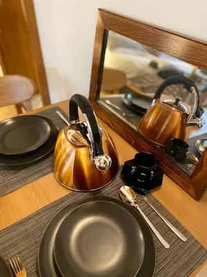 a tea kettle and plates on a table in front of a mirror at Apartment DeLuxe in Prague