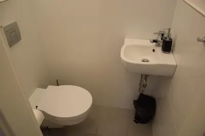 a white bathroom with a toilet and a sink at Apartment DeLuxe in Prague
