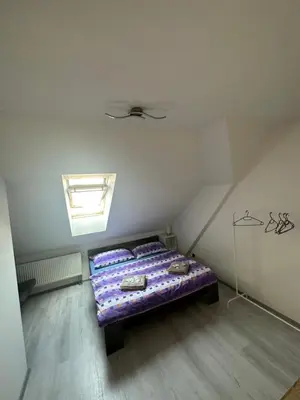 a bedroom with a bed with purple sheets on it at Penzion Arendel in Líšnice