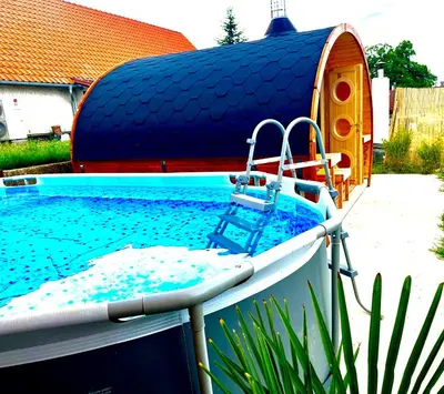 a swimming pool with a boat in a yard at Penzion Arendel in Líšnice