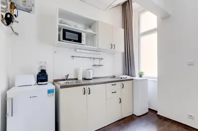 a white bedroom with two beds and a chair at Cool & Charming Apt in city center - lub5 in Prague