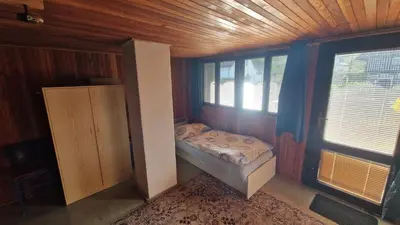 a kitchen with a stove and a living room at Chalupa Kruh in Doksy