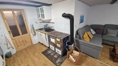 a living room with a couch and a wood stove at Chalupa Kruh in Doksy