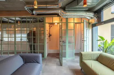 a living room with two couches and glass walls at Cool place in Prague