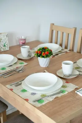 a wooden table with white plates and flowers on it at FREE PARKING- Newly built Apartment in Prague