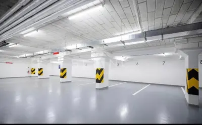 an empty parking garage with yellow and white columns at FREE PARKING- Newly built Apartment in Prague