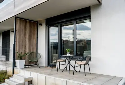 a patio with a table and chairs on a balcony at FREE PARKING- Newly built Apartment in Prague