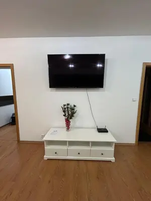 a white cabinet with a tv on a white wall at Krásné ubytování s balkonem in Prague