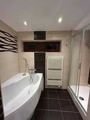 a bathroom with a large tub and a shower at Krásné ubytování s balkonem in Prague