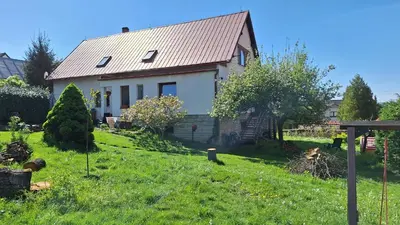 a white house with a metal roof on a green yard at Prague Zbraslav Old Garden in Prague