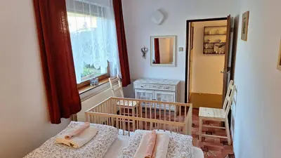 a small room with a crib and a window at Prague Zbraslav Old Garden in Prague