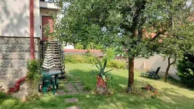 a table and chairs and a tree in a yard at Prague Zbraslav Old Garden in Prague