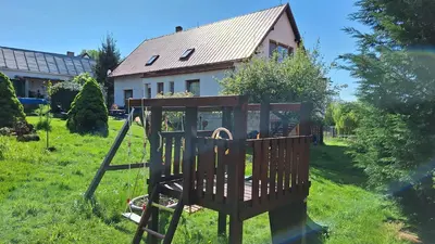 a playground in the grass in front of a house at Prague Zbraslav Old Garden in Prague