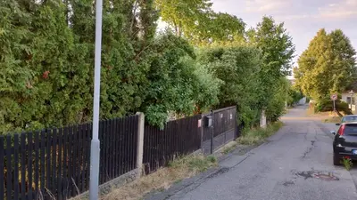 a fence on the side of a road with trees at Prague Zbraslav Old Garden in Prague