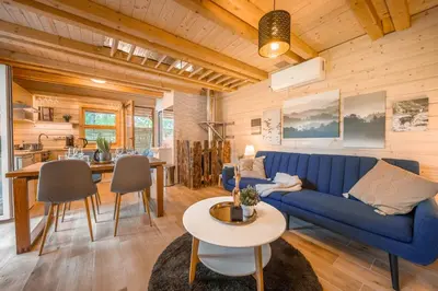 a living room with a blue couch and a table at Magic new cozy tiny house at private lake in Řehenice