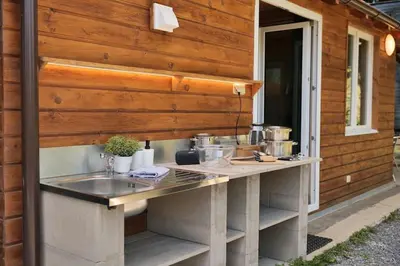 a counter with pots and pans on it next to a building at Magic new cozy tiny house at private lake in Řehenice