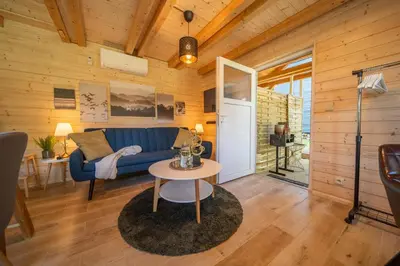 a living room with a blue couch and a table at Magic new cozy tiny house at private lake in Řehenice
