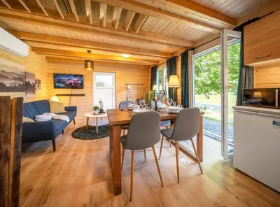 a kitchen and living room with a table and chairs at Magic new cozy tiny house at private lake in Řehenice
