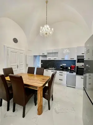 a kitchen with a wooden table and chairs at Masná 20C- Old Town Residence in Prague