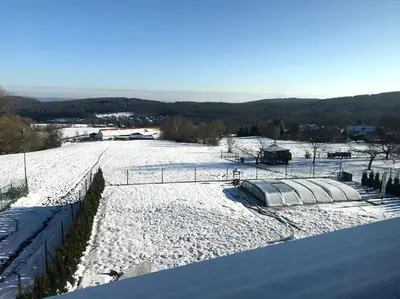 a snow covered field with a fence on top of it at Vila v Brdech s bazénem, infra saunou a vybavením in Malá Víska