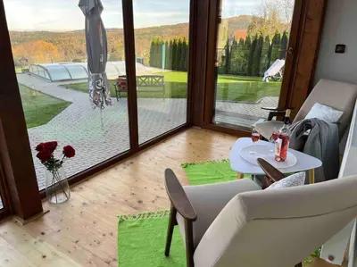 a room with a table and chairs and a large window at Vila v Brdech s bazénem, infra saunou a vybavením in Malá Víska