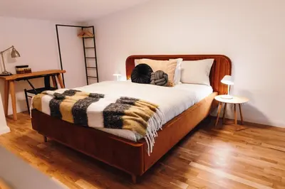 a bedroom with a large bed with a wooden floor at Modern Mezzanine Apt at Jecna st in Prague